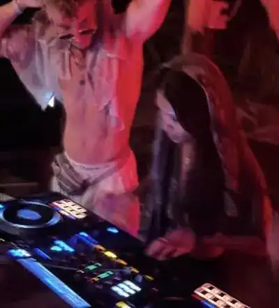 Amias behind the decks under red light