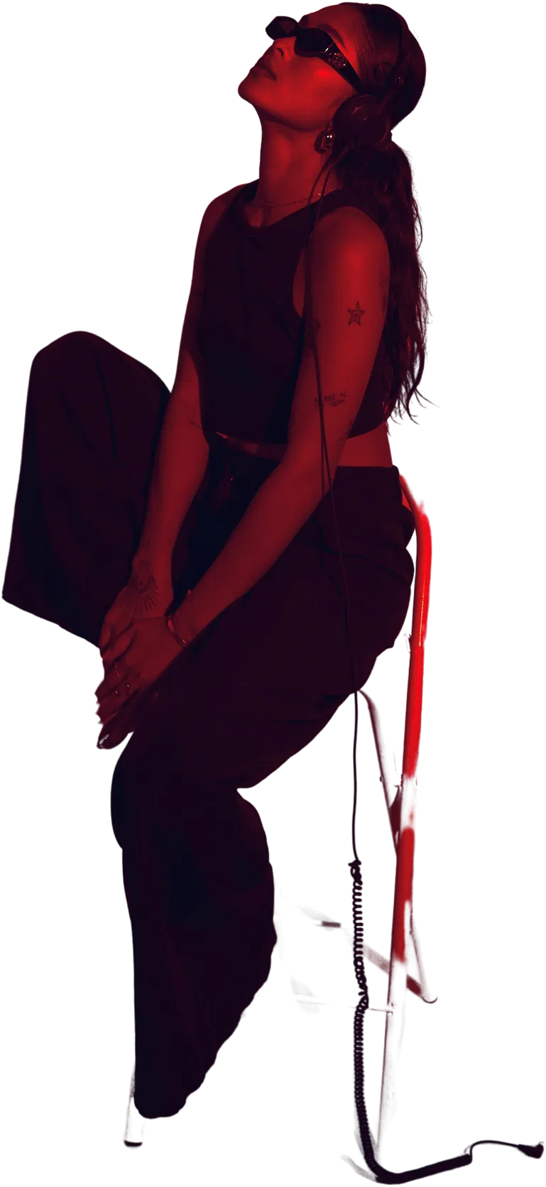 Amias seated, looking up, in warm red light